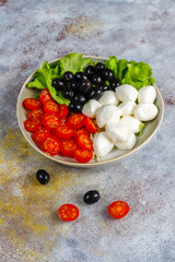 Salad with mozarella cheese, olives and cherry tomatoes.
