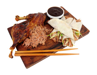 Aromatic half crispy duck with Chinese style pancakes and hoisin sauce on a wooden board isolated on a white background