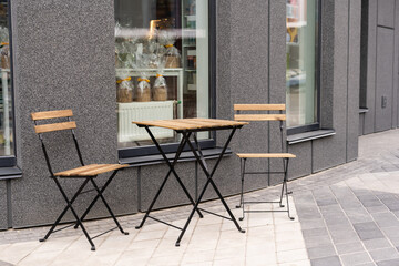 outdoor table and two chairs near the wall at coffee shop,