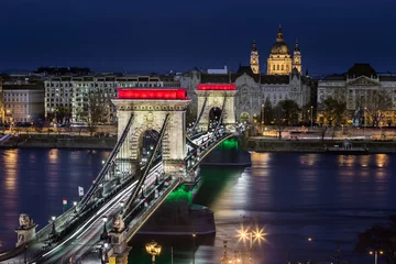 Photo sur Plexiglas Széchenyi lánchíd Budapest, Hungary - The world famous illuminated Szechenyi Chain Bridge (Lanchid) by night, lit up with national red, white and green colors with St.Stephen's Basilica at background on revolution day