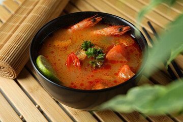 Concept of tasty eating with Tom yum soup on bamboo mat