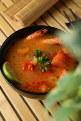 Concept of tasty eating with Tom yum soup on bamboo mat
