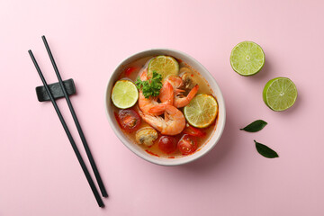 Tasty Tom yum soup on pink background