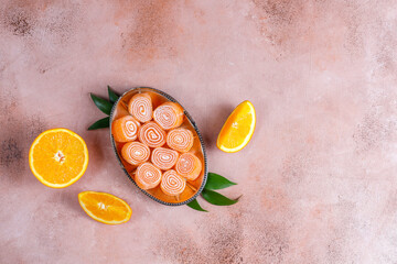 Orange color jelly rolls with orange fruits.