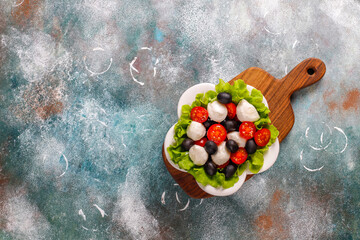 Salad with mozarella cheese, olives and cherry tomatoes.