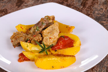 Baked pork meat with potao and tomato