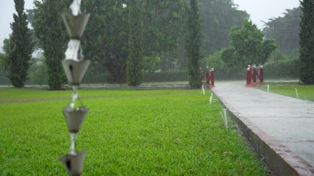 Water trickling down rain chain. Slow motion