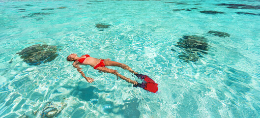 Snorkel woman swimming in the turquoise ocean sea relaxing floating on luxury travel vacation above...