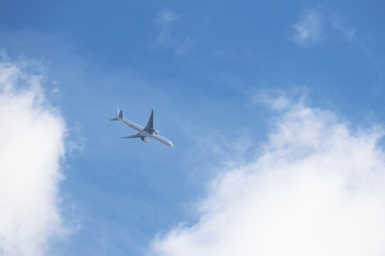 Airplane Flying In Blue Sky On Background Of White Clouds. Two-engine Commercial Plane, Turbulence And Travel Concept