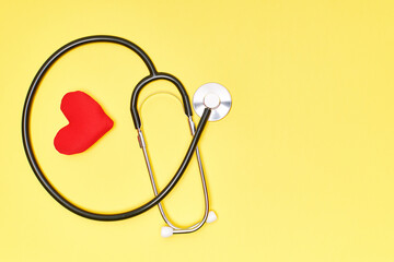 Stethoscope with a red heart on a yellow background. Health concept