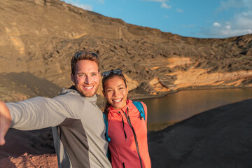 Travel summer Spain destination selfie of interracial couple tourists selfie photo on hike Asian...