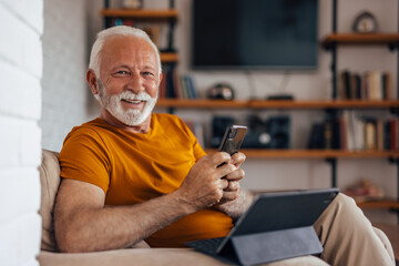 Mature man, posing for camera, while holding the phone.