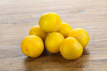 Ripe sweet yellow plum heap over background