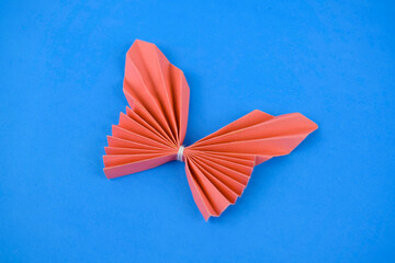 Pink butterfly made with small craft paper and nicely placed on a paper background