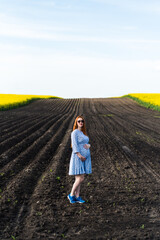 Pregnant woman on the summer field