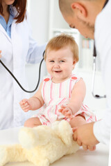 Happy smiling girl-child at usual medical inspection. Doctor and female toddler patient in the clinic. Medicine concept