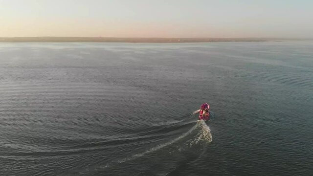 Aerial View Of Pink Speedboat With Passengers Turning On Keenjhar Lake In Thatta During Sunset. 