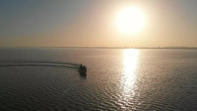 Aerial View Of Speedboat With People On Board Moving Across Keenjhar Lake In Thatta During Golding Hour