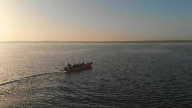 Speedboat With People On Board Moving Across Keenjhar Lake In Thatta During Golding Hour. Aerial View