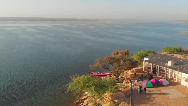 Aerial View Of Tourists Tent Camping Beside Keenjhar Lake Beside Building 