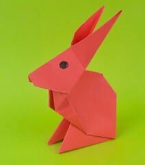 Single little rabbit made with small craft paper and nicely placed on a paper background