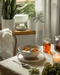 Granola with roasted plums and sage leaves on the table with linen tablecloth, tee, grape, still life, slow living, breakfast