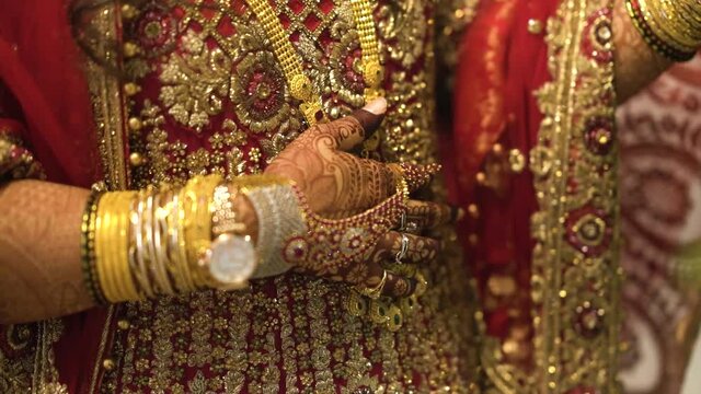 Close up of woman&rsquo;s hand with jewellery. Bride&rsquo;s hand decorated with mehndi, bangles, chain and golden watch. 