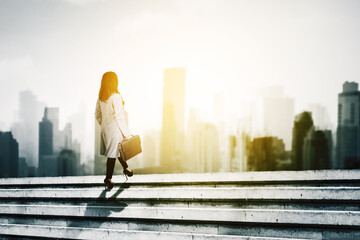 Businesswoman climbing stairs toward modern city