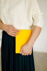 woman businessman holding a yellow notepad. Business planning and tasks for the day or week. Female in business