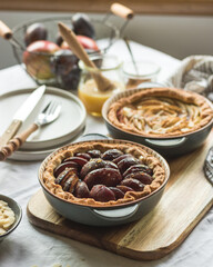 Plum and apple tart on the kitchen on the table with linen tablecloth, summer tart