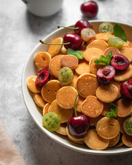 cereal pancackes with cherries and yogurt, berries, breakfast with woman hand