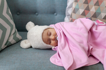 Sleeping little baby girl under pink blanket