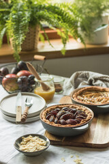 Plum and apple tart on the kitchen on the table with linen tablecloth, summer tart