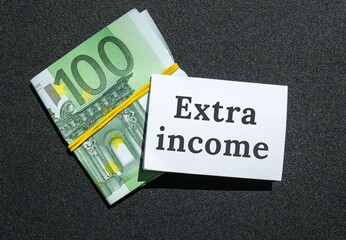 Euros cash money and paper note with text written EXTRA INCOME. Concept of financial planning. Make...