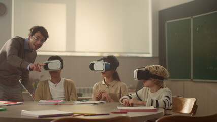 Students using vr glasses. teacher helping pupils to learn science with gadgets