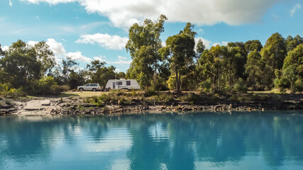 Landsscape view of a large modern caravan and four wheel drive vehicle free camping alongside a...