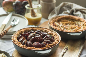 Plum and apple tart on the kitchen on the table with linen tablecloth, summer tart