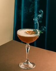 rosemary cocktail with whiskey and smoke on the brown and blue background, new wave food photography