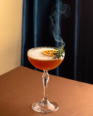 rosemary cocktail with whiskey and smoke on the brown and blue background, new wave food photography