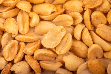 Roasted salted peanuts, surface texture. Close-up, selective focus.