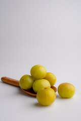 Ayurvedic Amla or Indian Gooseberry Juice, healthy diet on Wooden spoon on white background