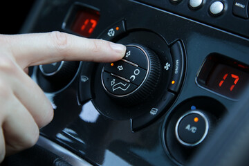 Hand ajusting the air conditioner in the car