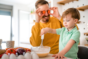 Smiling father with kids preparing healthy food and spending time together