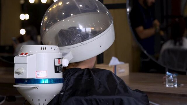 A woman in a beauty salon under a hair steamer for  - 120fps slow motion