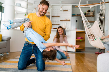 Obraz premium Happy young family having fun times and playing together at home