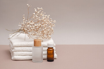 a set of towels and two jars on a light background, spa concept, moisturizing and nourishing the skin, body care, cosmetology and dermatology