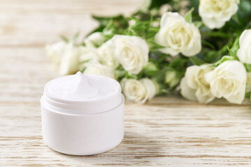 Fototapeta na wymiar Moisturizing cream for sensitive skin, spa cosmetic and natural clean skincare product on a background of white roses.