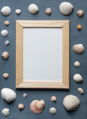 Sea vacation stationery mock-up scene. Blank white greeting card in wooden frame surrounded by colorful sea shells on textured gray background.