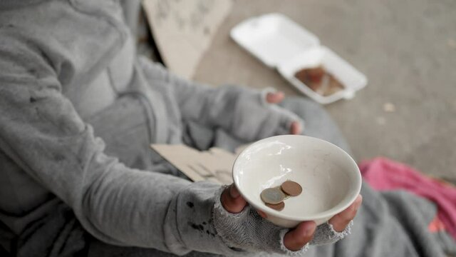 Homeless man with dirty clothes holding a cup and getting some money from kind peoples. 4K