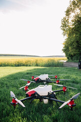 Obraz na płótnie Canvas Modern drone flying over wheat grain field on sunny day. Agriculture industry